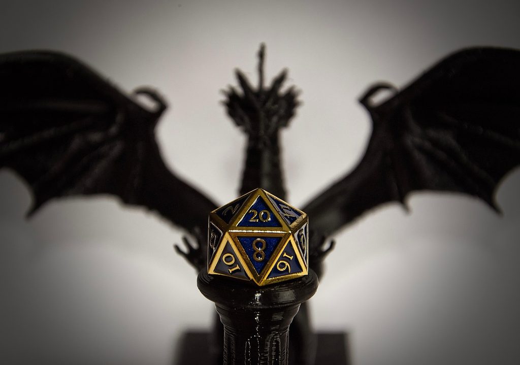 Dragon with wings out. A d20 dice in center.